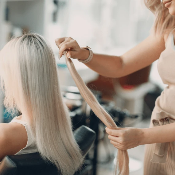 Image of woman sitting for hair extensions at Lusso Hair Studio & Spa located in Winston-Salem, NC